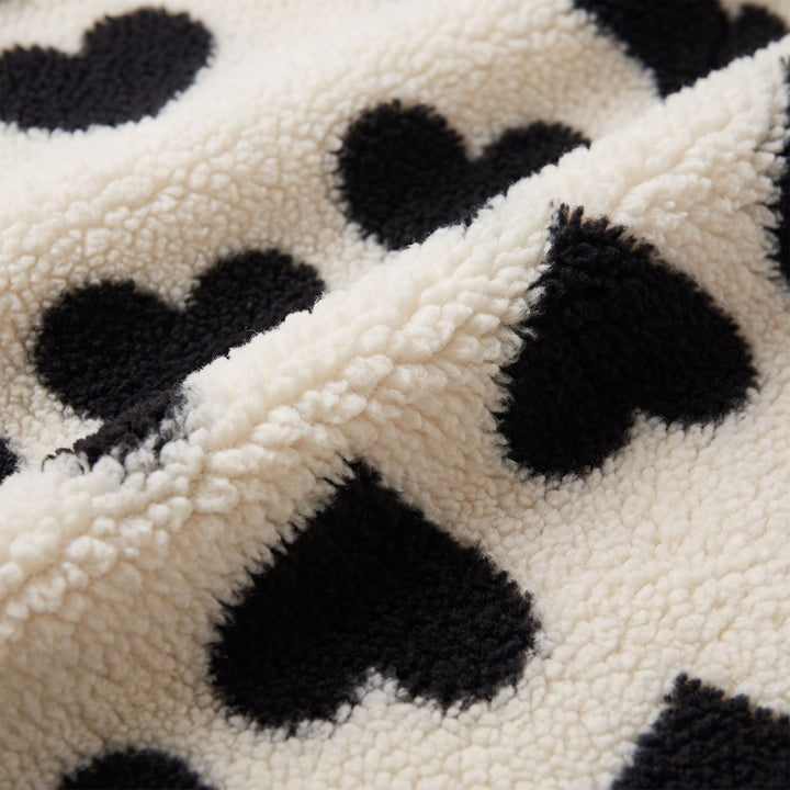 Close-up of cream sherpa fleece with black hearts