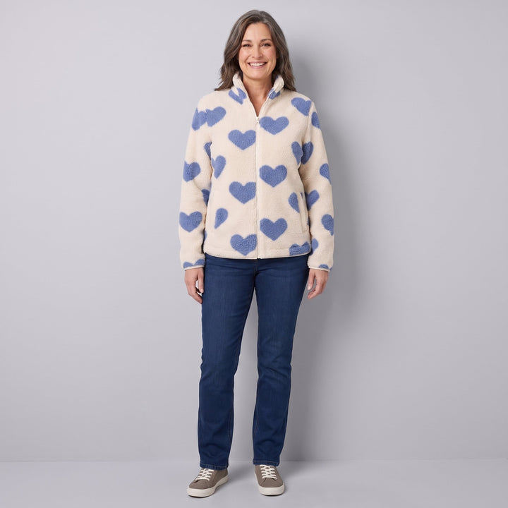 Woman wearing a cream sherpa jacket with blue hearts, front view