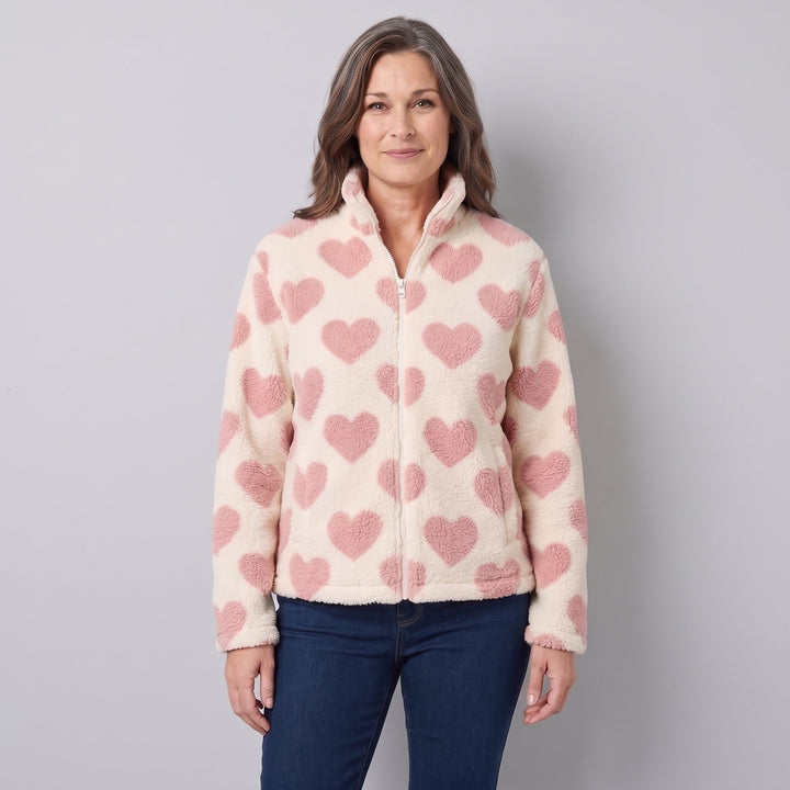 Woman wearing a cream sherpa jacket with pink hearts, front view