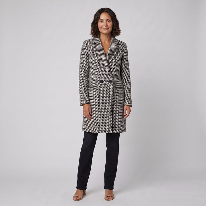 Woman wearing a black and white herringbone tailored winter coat, front view