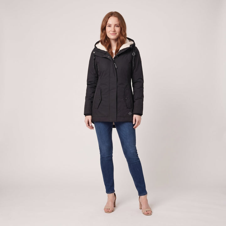 Woman wearing a black fleece-lined hooded parka, front view