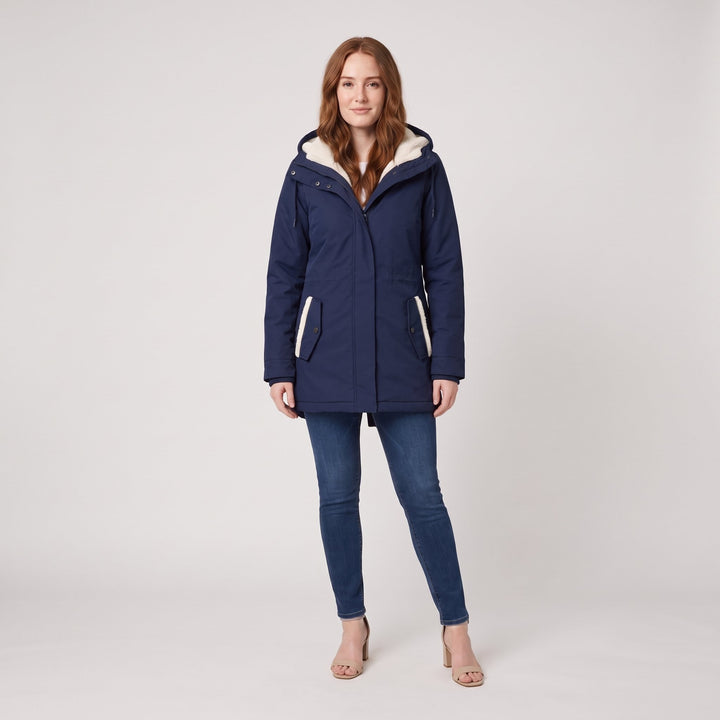 Woman wearing a navy blue fleece-lined hooded parka, front view