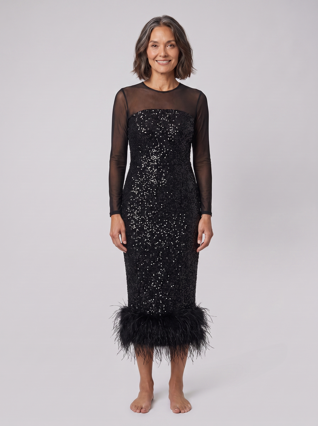 Black sequin midi dress with mesh sleeves and feather hem, front view on model
