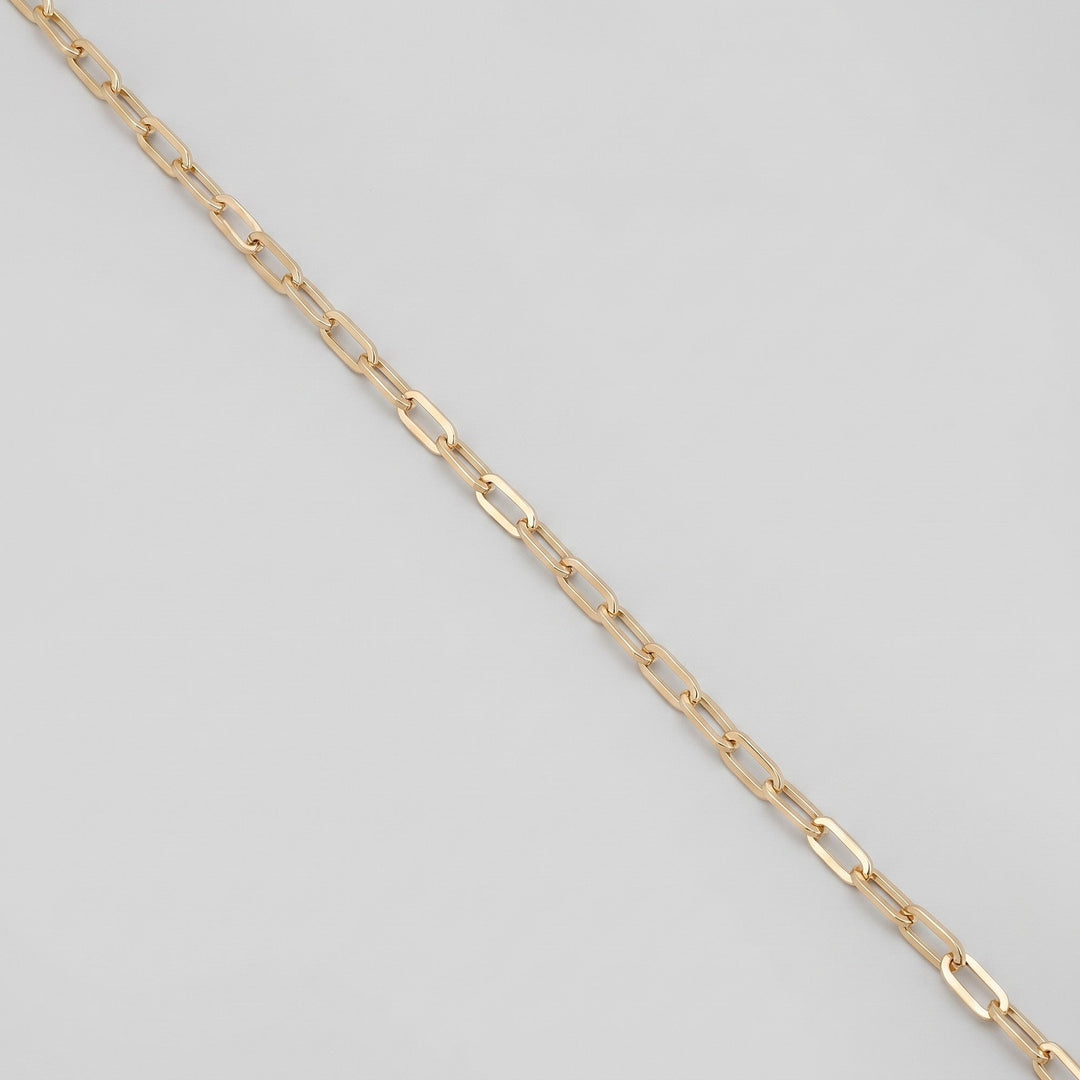 Gold body chain draped, showing flat cable links