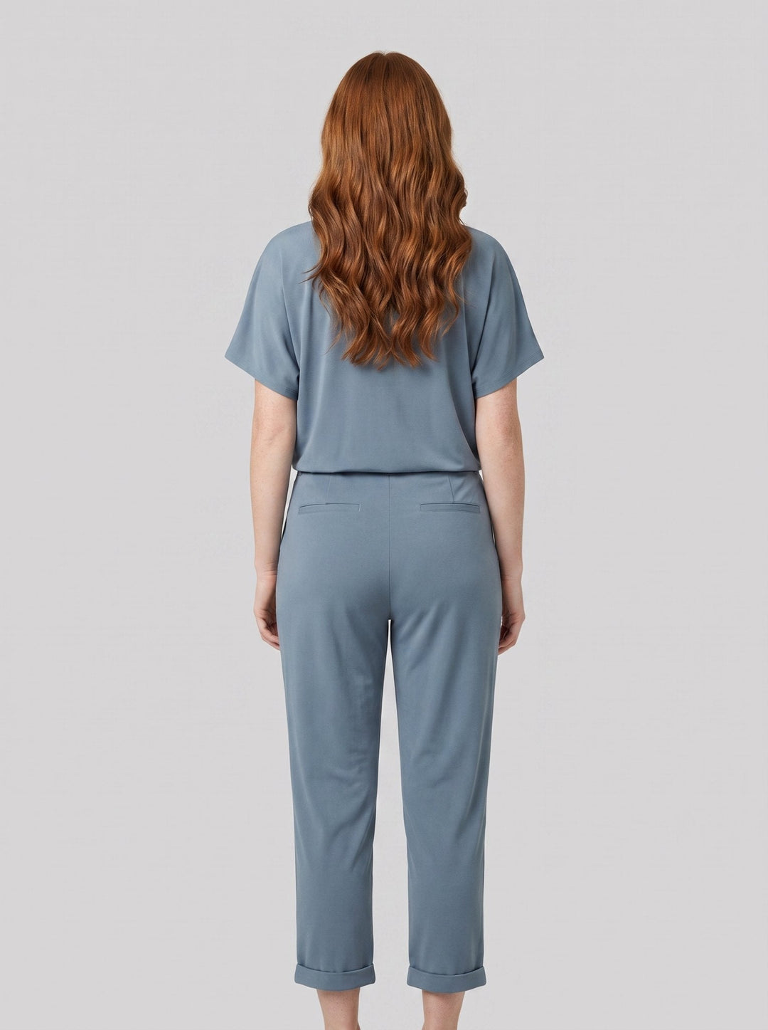 Lyra draped knot jumpsuit in dusty blue, back view on model