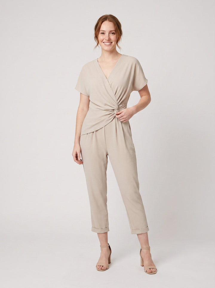 Lyra draped knot jumpsuit in beige, wrap V-neck with knotted waist, on model