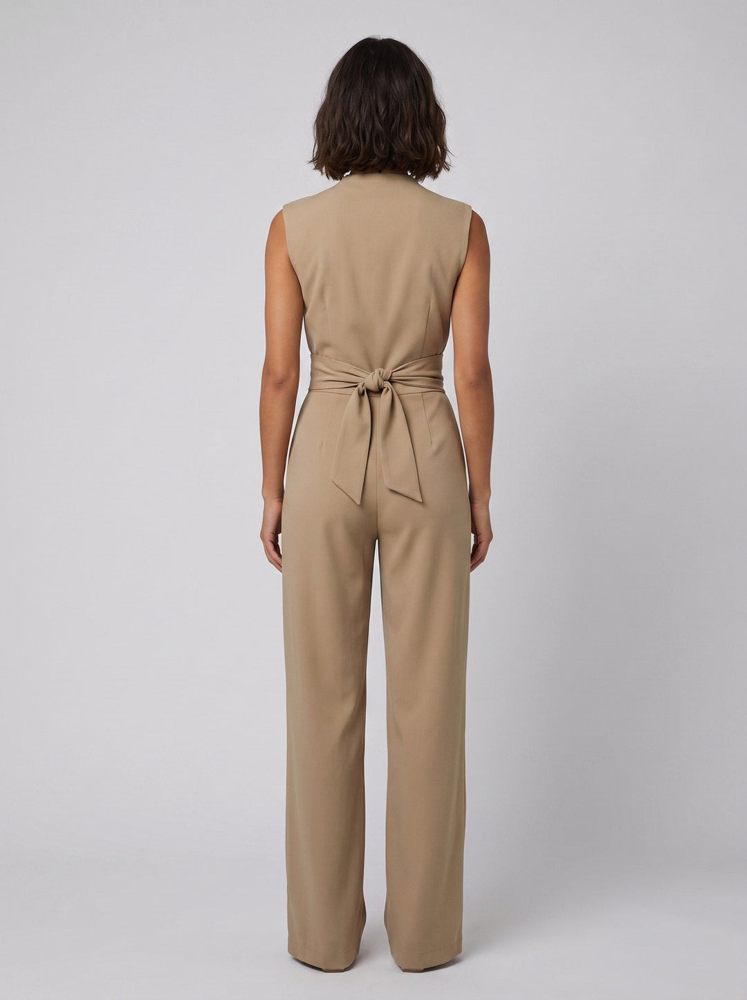 Malin Tassou chic sleeveless overall in khaki tan, back view on model