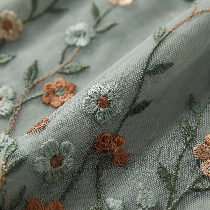 Close-up of the sage green floral embroidered mesh overlay
