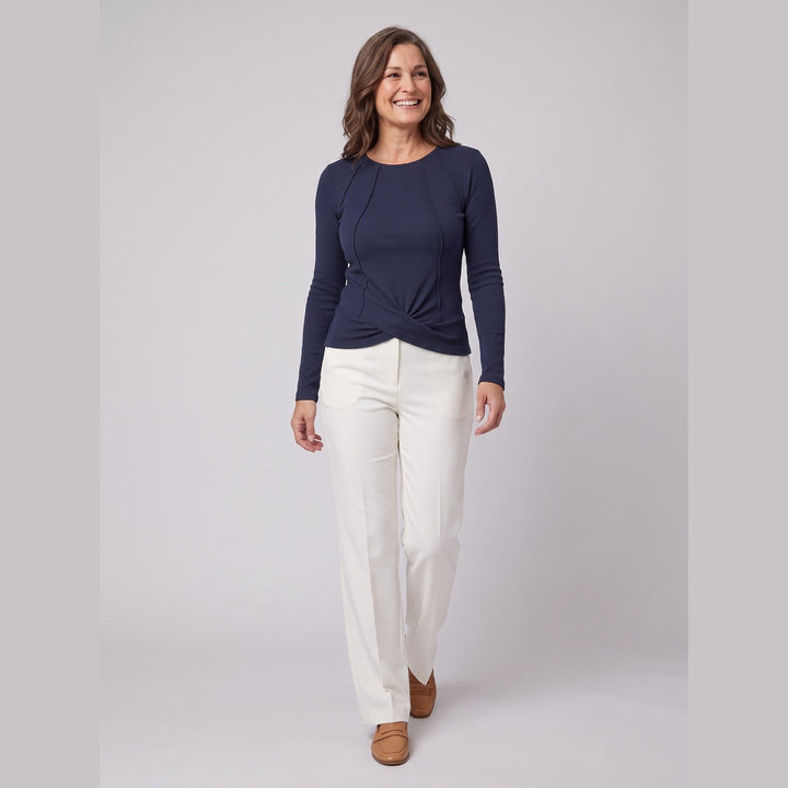 Marine blue ribbed knit long sleeve top with twist front hem, walking pose on model