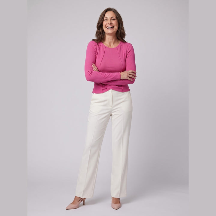 Pink ribbed knit long sleeve top with twist front hem, relaxed pose on model