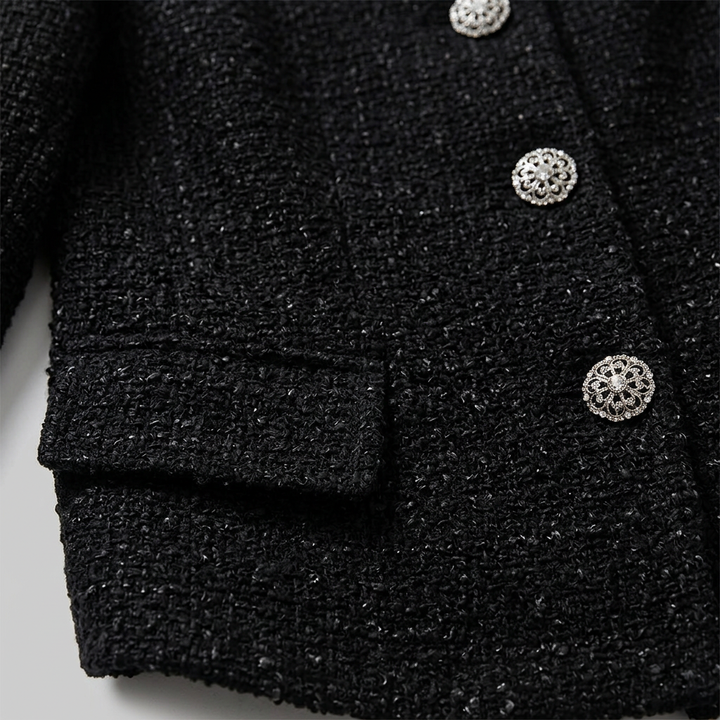 Close-up of the decorative buttons and flap pocket on the tweed jacket