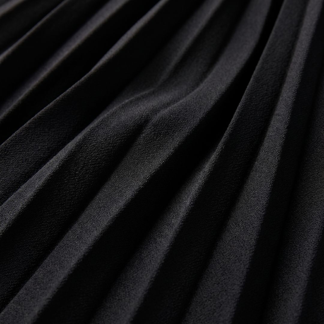 Close-up of the pleated fabric and metal belt buckle in black